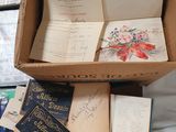 a box full of books on top of a pile of books