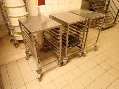 plusieurs plateaux de nourriture posés sur un chariot dans la cuisine