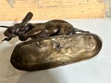 a bronze statue of a dog laying on top of a banana