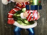 a statue of a elf holding a stack of presents