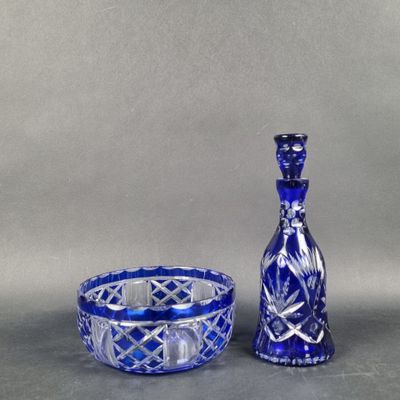 un vase en verre bleu et un bol en verre bleu posés sur une table