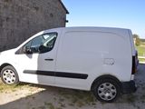 une camionnette blanche garée devant un immeuble en briques