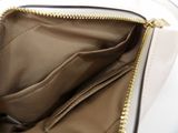the inside of a white purse with gold zippers on it
