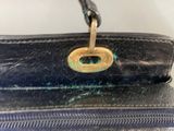 a close up of a black purse with a metal handle