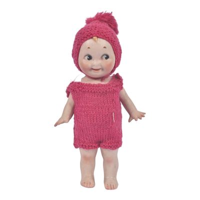 pink knitted baby doll wearing a pink knitted hat and dress