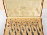 six silverware spoons in a wooden case with a gold lining