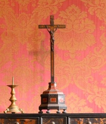 une croix posée sur une commode, avec une bougie