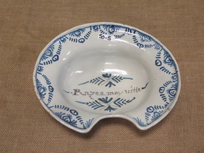 une assiette bleue et blanche sur laquelle figure un nom