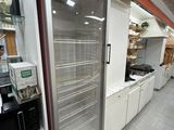 un réfrigérateur au milieu d'un magasin rempli de produits alimentaires