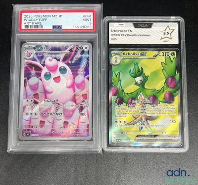 two pokemon cards are in plastic cases on a table