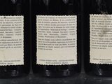 three bottles of wine are lined up on a table