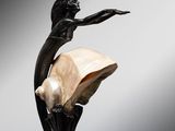 a statue of a woman holding a shell on top of a table