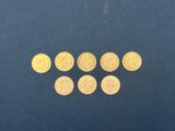 un gros plan sur un tas de pièces d'or posées sur une surface bleue