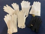 four pairs of white gloves on a blue surface