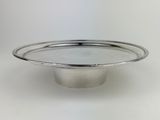 a close up of a silver plate on a white surface