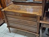 a wooden desk with a mirror on it in the corner of a room