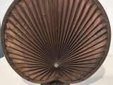 une photo d'un éventail en bois posé sur une table blanche