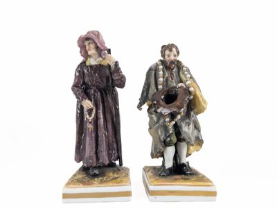 pair of figurines of a man and a woman on marble bases