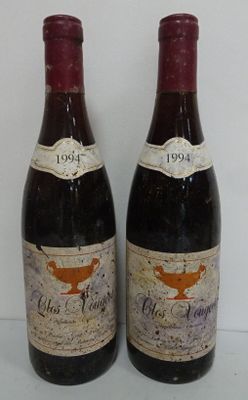 two bottles of red wine sitting next to each other on a table