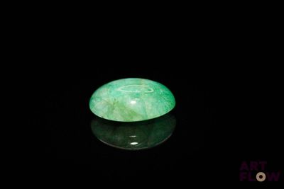 an image of a green jade stone sitting on top of a black surface