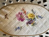 a white basket with flowers on it on a table