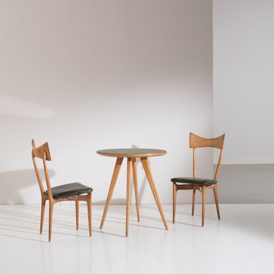 two chairs and a table in a room with a white wall