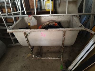 a bath tub with a chicken in it in a garage