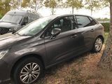 a picture of a grey car parked next to a tree