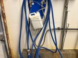 a blue hose attached to a wall next to pipes and pipes