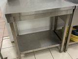 a stainless steel table in a kitchen with a sink and a dishwasher