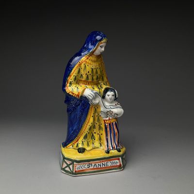 figurine d'une femme tenant un enfant dans ses bras