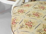 a close up of a chair with a floral upholstered seat