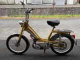 a small yellow bike parked on the side of the road