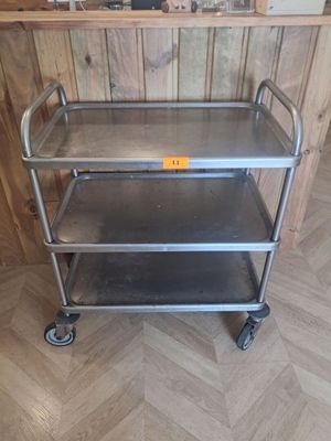 un chariot en métal posé sur un plancher en bois