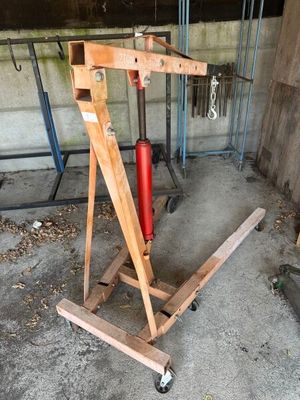 un extincteur rouge posé sur un support en bois dans un garage