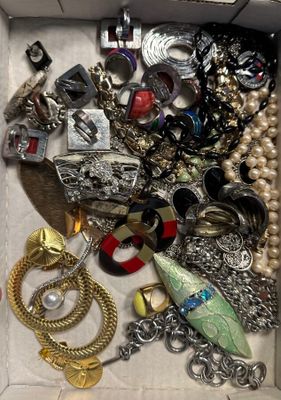 une boîte remplie de bijoux assortis sur une table