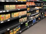 many shelves of food in the store with drinks on them