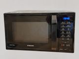 a black microwave oven with a digital clock on it