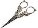 a pair of scissors that are sitting on a white surface