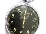 a close up of a pocket watch on a white surface