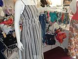 two mannequins in a clothing store with a woman in the background