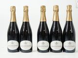 quatre bouteilles de champagne sont alignées sur une surface blanche
