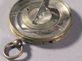a silver compass on a table with a ring around it