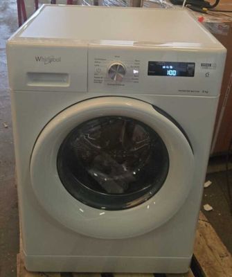 une machine à laver posée sur une palette dans un entrepôt