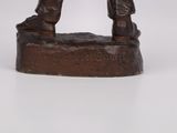 bronze statue of a man holding a rifle on a white surface