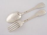 two silver spoons and a fork on a white surface