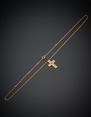 un collier avec une croix en or et une chaîne en or sur fond noir