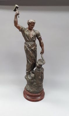 statue d'un homme tenant un marteau et un marteau à la main