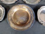 several silver plates with ornate designs on them on a table