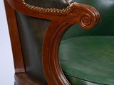 an image of a green leather chair sitting on top of a wooden table